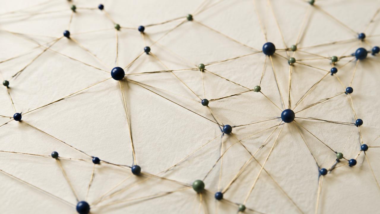 An abstract network of brass threads connecting small nodes on paper